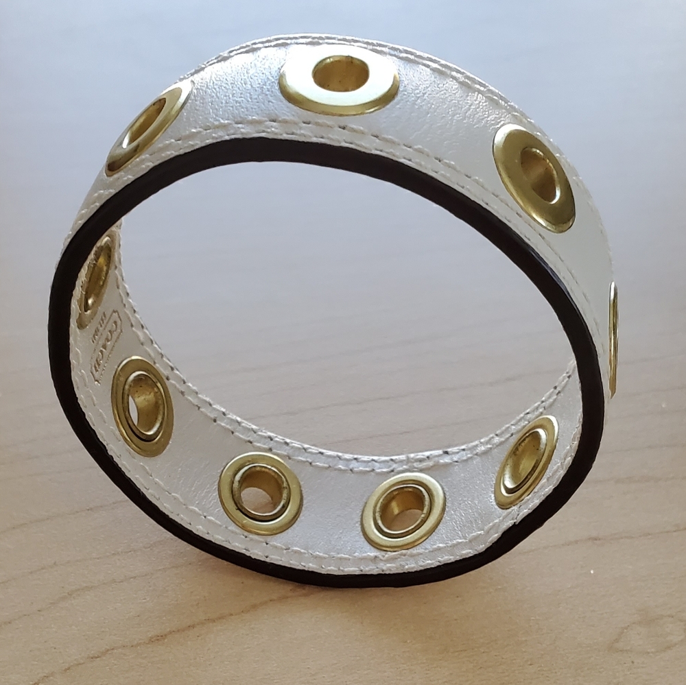 COACH cream leather 1 inch bracelet with yellow gold brass grommets.